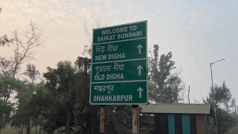 Cinematic-view-of-a-green-board-showing-direction-of-places-with-arrows-in-white-ink-in-Kolkata,-India