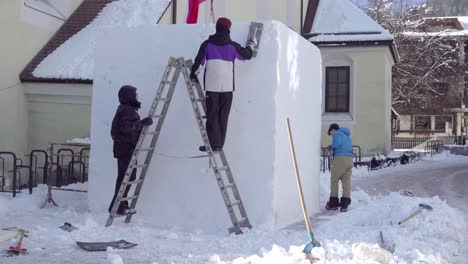 Estudiantes-Austriacos-De-Htl-Trabajan-En-Su-Escultura-De-Nieve,-Sinergia,-Durante-El-33º-Festival-De-Nieve-De-Los-Dolomitas-En-Innichen---San-Candido,-Tirol-Del-Sur,-Italia