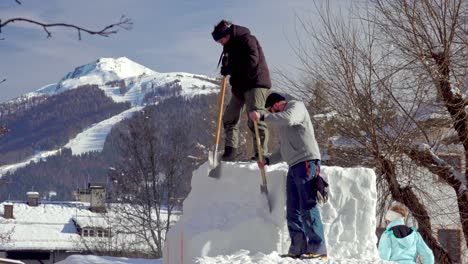 German-Artists-work-on-their-snow-sculpture,-The-Chip-Monkey,-during-the-33rd-Dolomites-Snow-Festival-in-Innichen---San-Candido,-South-Tyrol,-Italy