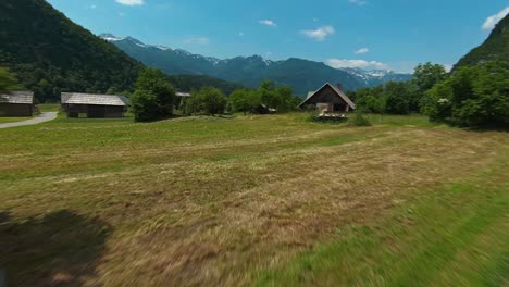 Flug-über-Ackerland-Und-Holzhäuser-Im-Bergdorf-In-Der-Nähe-Des-Bohinjer-Sees,-Slowenien