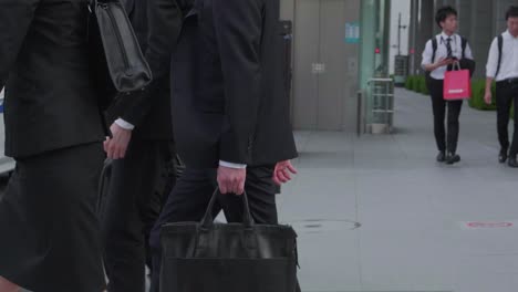 japanese-business-people-cross-a-street-in-tokyo,-japan-in-business-attire