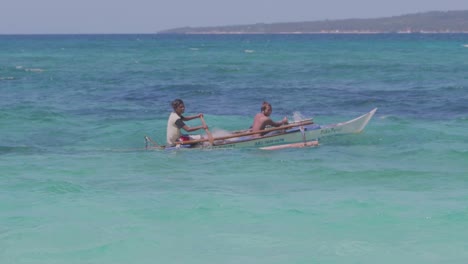 Dos-Jóvenes-Remando-En-Un-Pequeño-Bote-Sobre-El-Océano-Pacífico-En-Filipinas