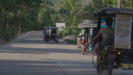 several-tricycle-driving-down-a-road-in-the-philippines