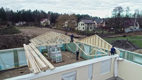 Trabajadores-De-La-Construcción-Instalando-Vigas-De-Madera-Y-Vigas-En-El-Techo-De-La-Casa