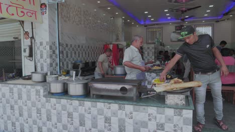 Gente-En-Cámara-Lenta-Haciendo-Comida-Tradicional-India-En-La-Calle-En-Un-Puesto-Del-Mercado-Al-Lado-De-La-Carretera