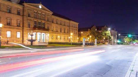 Un-Hermoso-Timelapse-Del-Edificio-Histórico-De-La-Universidad-De-Tubinga-Por-La-Noche-Con-Una-Fuente-De-Agua-Y-Autos-Avanzando