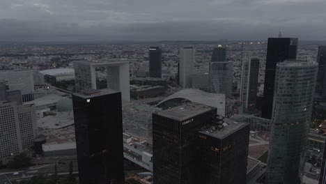 Aerial-drone-shot-of-the-modern-La-Defense-business-district-in-Paris,-France-in-the-early-morning-on-a-cloudy-day