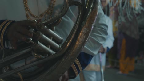 a-traditional-indian-man-is-playing-an-instrument-at-a-religious-festival-at-night