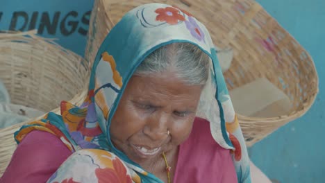 a-very-old-but-funny-looking-indian-woman-sitting-on-a-street-in-Jaipur-with-a-colorful-headscarf