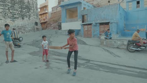 Retrato-De-Niño-Indio-Sonriendo-A-La-Cámara-En-La-Calle-En-La-India-Con-Una-Expresión-Feliz-Jugando-Al-Cricket