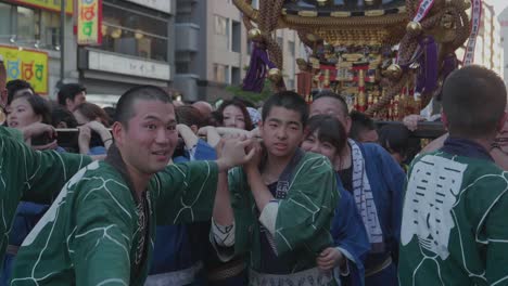 Multitudes-De-Personas-Caminando-Por-Las-Calles-De-Japón-Llevando-Una-Gran-Estatua-Budista.