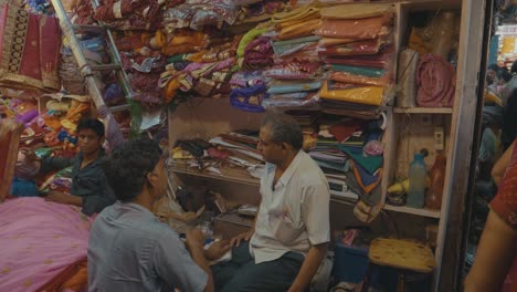 Caminando-Por-Un-Mercado-Indio-Con-Coloridas-Tiendas-Llenas-De-Artículos-Para-Comprar-Ocupado-Con-Gente-Local