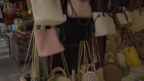 Walking-past-the-market-stalls-viewing-all-the-merchandise-as-shoppers-browse-the-items-for-sale-in-Cala-De-Mijas-market