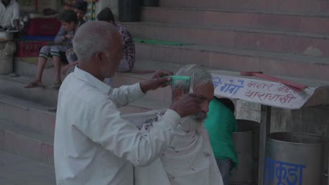 Indian-Man-Giving-A-Haircut-On-The-Side-Of-The-Road-At-A-Market-Stall