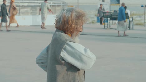 a-old-indian-guy-with-orange-dyed-hair-walking-in-Rishikesh,-India