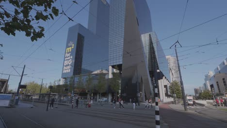 Toma-Panorámica-De-Rascacielos-En-Rotterdam-Y-Gente-Caminando.