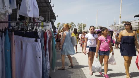 Shoppers-wander-by-in-the-main-aisle-of-the-market-of-Cala-De-Mijas-as-the-camera-slowly-lowers