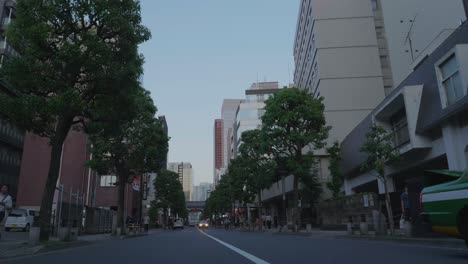 Cars-and-cabs-driving-through-the-streets-of-Tokyo,-Japan-in-the-early-evening