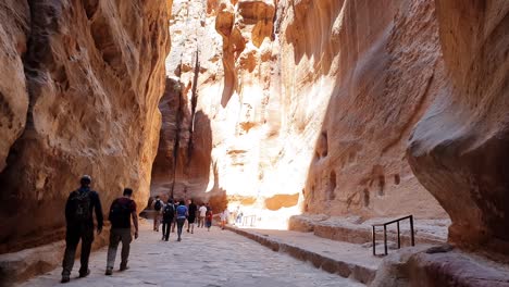 Touristen-Wandern-Zwischen-Den-Hohen-Schluchtwänden-Auf-Dem-Weg-Zur-Antiken-Stadt-Petra