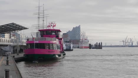 Eine-Rosafarbene-Fähre-In-Hamburg,-Deutschland-Mit-Der-Berühmten-Elbphilharmonie-Im-Hintergrund