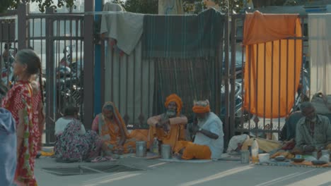 Indian-people-walking-past-several-Hindu-Gururs-in-Rishikesh,-India