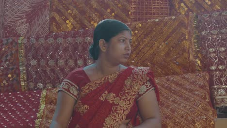 A-woman-in-traditional-red-clothes-from-India-sitting-in-a-red-tent-in-Delhi,-India