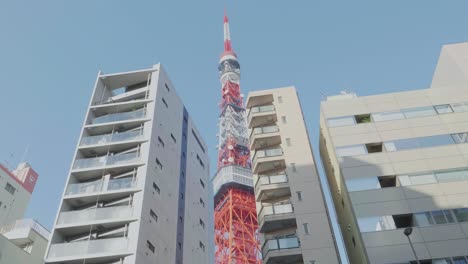 Tokyo-Tower-in-the-centre-of-Tokyo,-Japan-seen-between-some-high-residentail-buildings