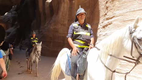 Los-Turistas-Se-Hacen-A-Un-Lado-Para-La-Policía-De-Tránsito-A-Caballo-Mientras-Pasan-Por-Los-Pasillos-De-Petra-En-Jordania