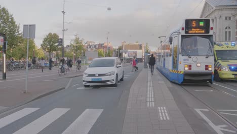 Coche-De-Ambulancia-Corriendo-Por-El-Centro-De-Ámsterdam-Con-Luces-Azules-Intermitentes-Y-Sirena.