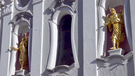 Main-facade-of-Saint-Michael-Parish-Church-with-niches-with-statues-and-a-window-in-Innichen---San-Candido,-South-Tyrol,-Italy