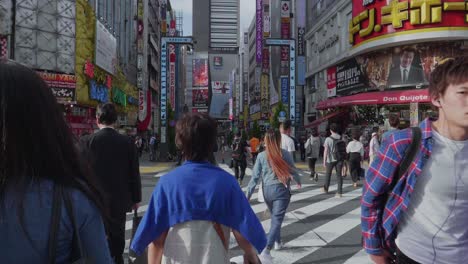 Many-japanese-people-cross-a-packed-road-in-Shinjuku,-Tokyo-while-rush-hour