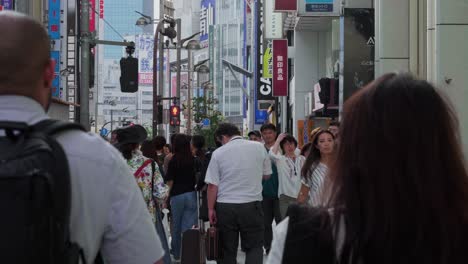 Many-pedestrians-walking-in-the-Streets-of-Shinjuku,-Tokyo,-Japan-on-an-overcast-day