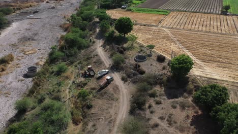 Aerial-drone-view-phone-camera-man-filling-bug-and-putting-it-in-tractor-Many-trucks-are-standing