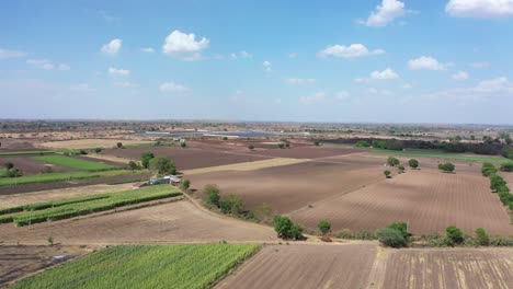 Aerial-drone-view-phone-camera-moving-forward-showing-many-large-fields-and-solar-farm