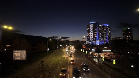 Tráfico-De-Vehículos-En-&#39;bulgaria-Boulevard&#39;-Por-La-Noche,-El-Restaurante-McDonald&#39;s-Y-Edificios-De-Gran-Altura-A-La-Derecha