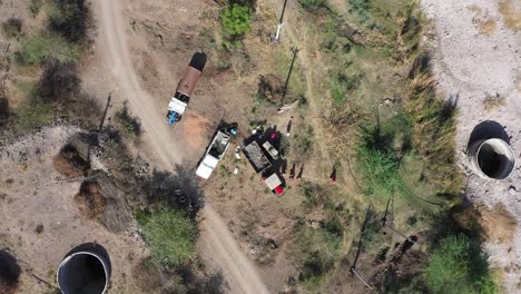 Aerial-drone-view-camera-showing-men-mixing-cement-and-gravel-in-a-machine