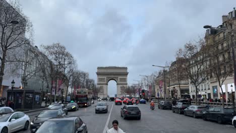 Traffic-flowing-towards-the-Arc-de-Triomphe-in-Paris-on-an-overcast-day,-city-vibe,-timelapse