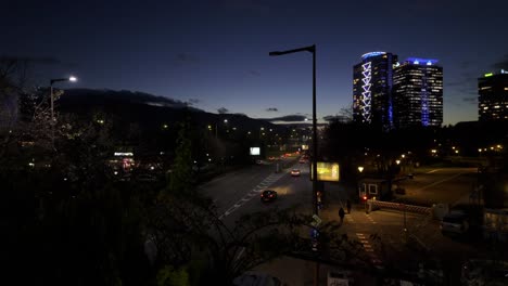 Tráfico-De-Vehículos-En-&#39;bulgaria-Boulevard&#39;-Por-La-Noche,-Edificios-De-Gran-Altura-A-La-Derecha