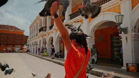 Joven-Viajera-Jugando-Con-Palomas-En-Las-Calles-De-Cartagena-De-Las-Indias,-Colombia,-Sudamérica