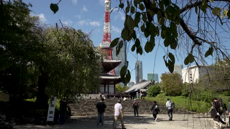 Los-Visitantes-Suben-Los-Escalones-Del-Templo-Budista-Zojo-ji-Con-La-Torre-De-Comunicaciones-De-La-Ciudad-Como-Telón-De-Fondo