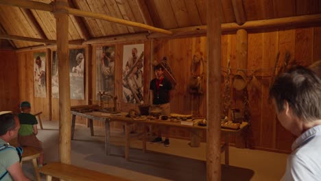 Indoor-view-of-a-presenter-at-an-Ice-Age-museum-exhibition-in-Friedrichshafen,-engaging-with-visitors