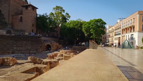 Centro-Histórico-De-Málaga,-Calle-Alcazabilla,-Su-Pirámide-De-Cristal-Y-El-Antiguo-Teatro-Romano-A-Un-Lado