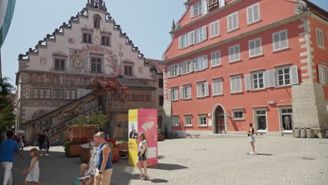 Día-Soleado-En-Lindau-Con-Turistas-Paseando-Por-Edificios-Históricos-Pintados,-Cielo-Azul-Claro