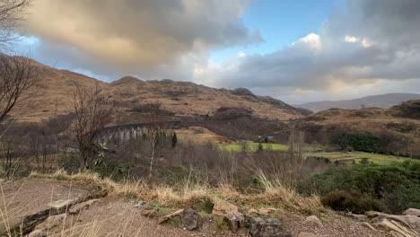 Excursionistas-Con-Vistas-Al-Histórico-Viaducto-De-Glenfinnan-En-Medio-De-Las-Tierras-Altas-Escocesas,-Cielos-Nublados,-Timelapse