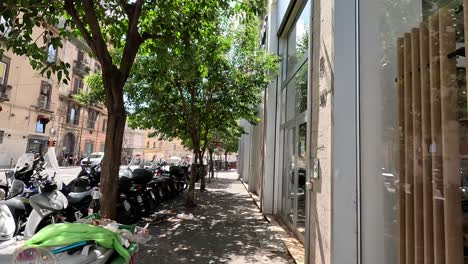 POV-shot-of-walking-street-with-garbage-containers-and-scooters-to-the-city-center-of-Naples-in-Italy