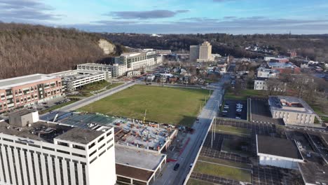 parking-garage-construction-in-Frankfort-Kentucky-near-the-Capital-Plaza-Hotel-over-the-Kentucky-river-with-traffic-at-sunset-AERIAL-DOLLY