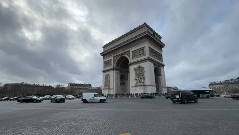 Toma-Gran-Angular-Del-Arco-Del-Triunfo-En-París-Con-Tráfico-Intenso,-Cielo-Nublado,-Timelapse