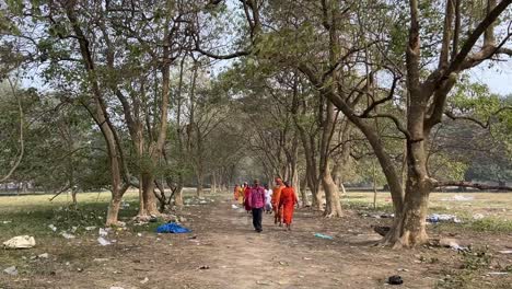 Vista-Frontal-De-Gran-Angular-De-Unos-Sadhus-Caminando-Por-Un-Sendero-De-Bosque-En-Kolkata,-India