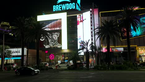 Incline-La-Vista-Desde-El-Otro-Lado-Del-Strip-De-Las-Vegas-Para-Revelar-El-Letrero-Iluminado-De-Brewdog-En-La-Parte-Superior-Del-Edificio-Por-La-Noche.