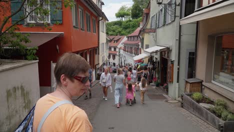 Calle-Europea-Concurrida-En-Meersburg-Con-Turistas-Caminando,-Edificios-Antiguos,-Ambiente-De-Verano,-Toma-Manual.